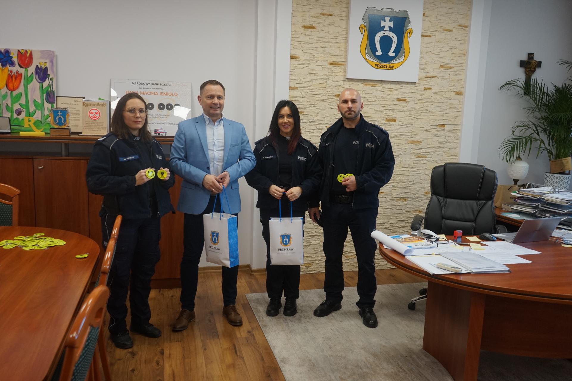 Burmistrz Przecławia Maciej Jemioło przekazuje odblaski przedstawicielom Policji